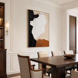 Gold-framed abstract wall art displayed above upholstered chairs in a refined dining room.