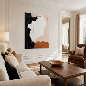 Frameless abstract wall art beside leather seating in a sunlit neutral living room.