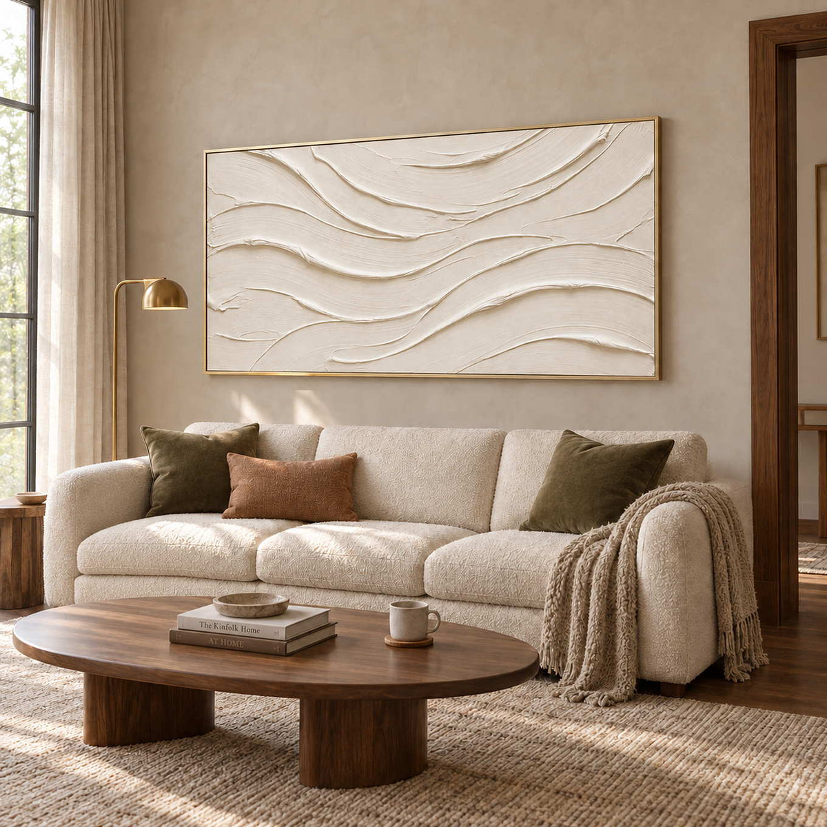 An Unhurried Flow in a gold frame above a cream sofa with olive cushions and a low oval wood coffee table.