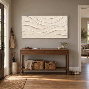 An Unhurried Flow in a silver frame above a wood entryway console with woven baskets beneath.