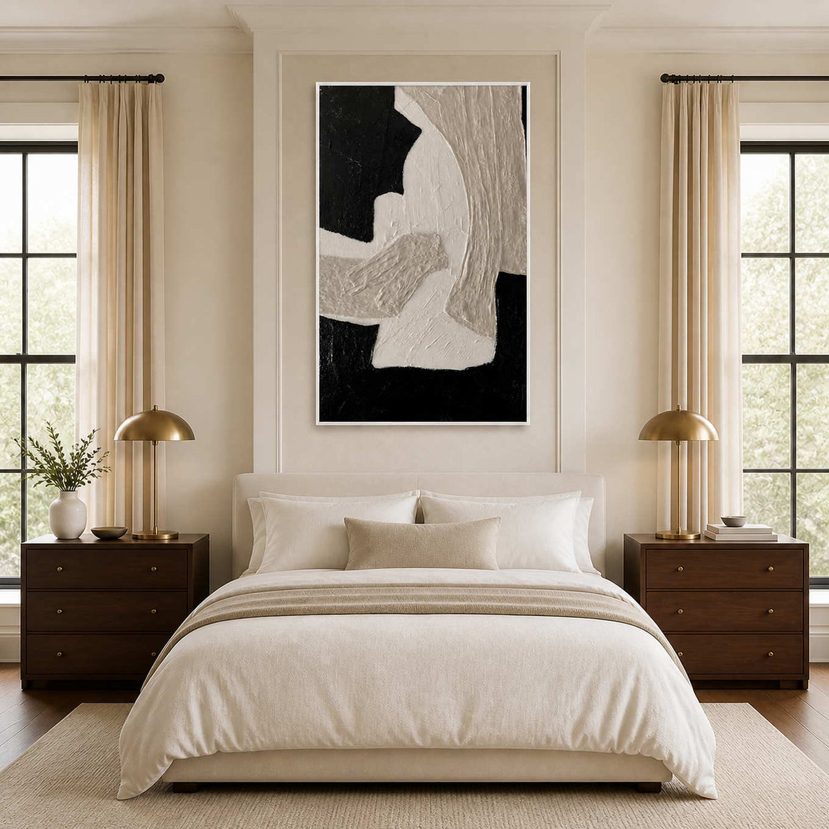 White framed black and gray abstract wall art above a cream bed.