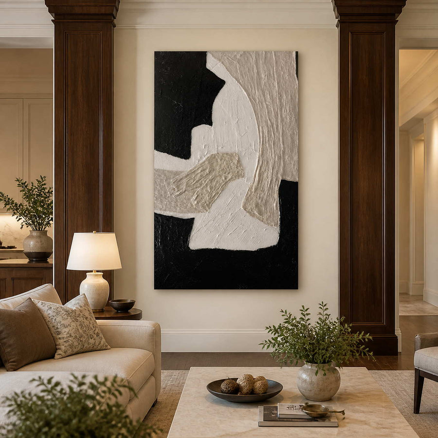 Frameless black and white textured artwork beside a cream living room sofa.