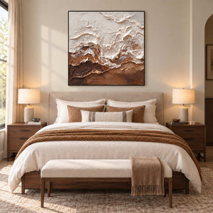 At Ease in a black frame above a cream bed with brown accents and a cushioned bench.