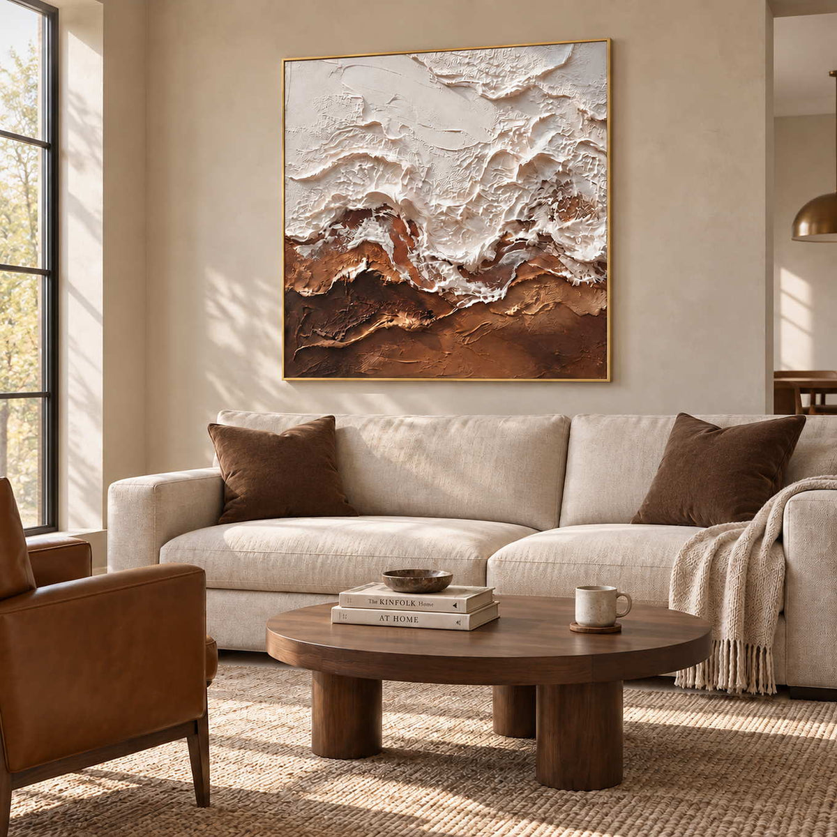 At Ease in a gold frame above a cream sofa with brown cushions and a round wood coffee table.