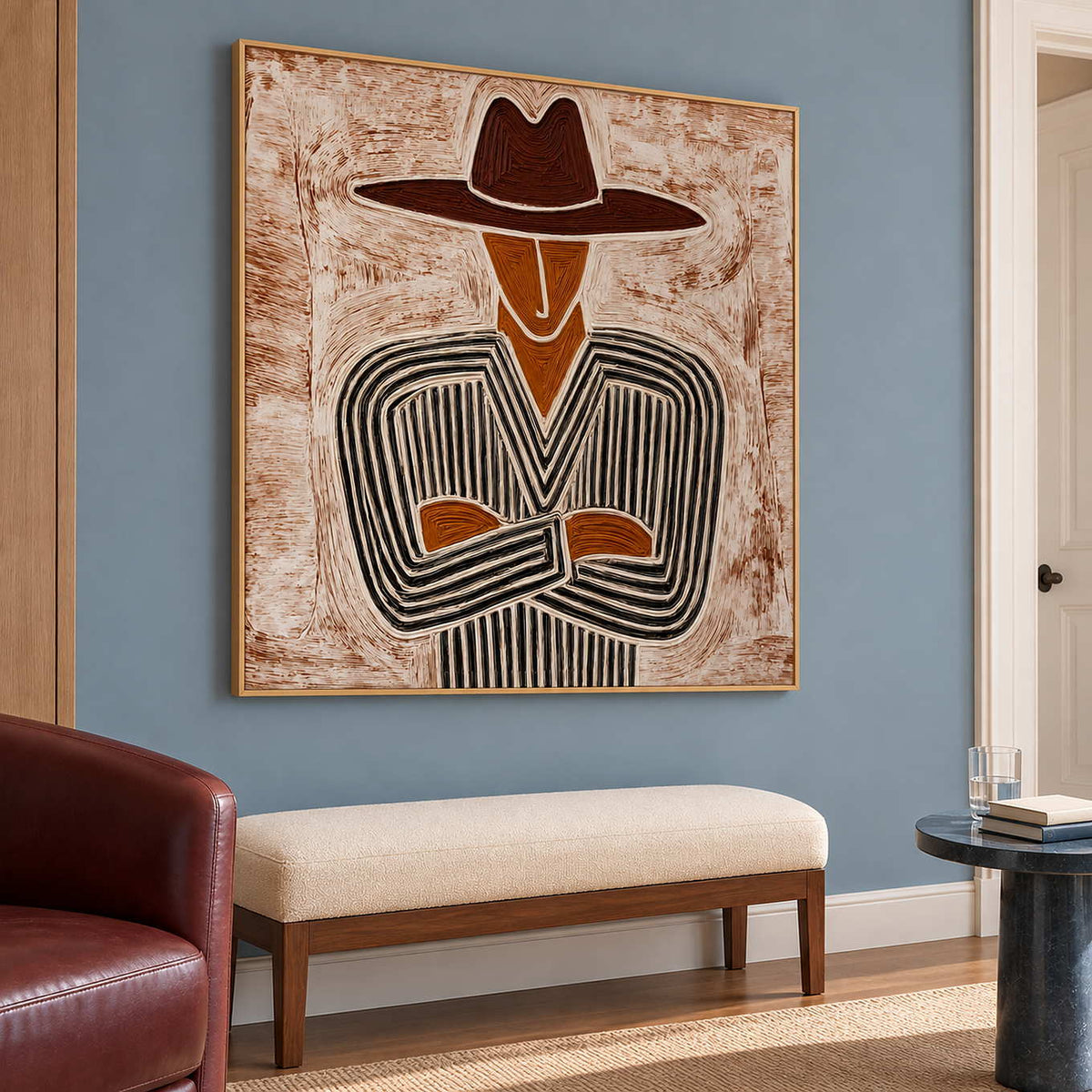 Folded-arm figure painting above a cream bench against a muted blue wall.