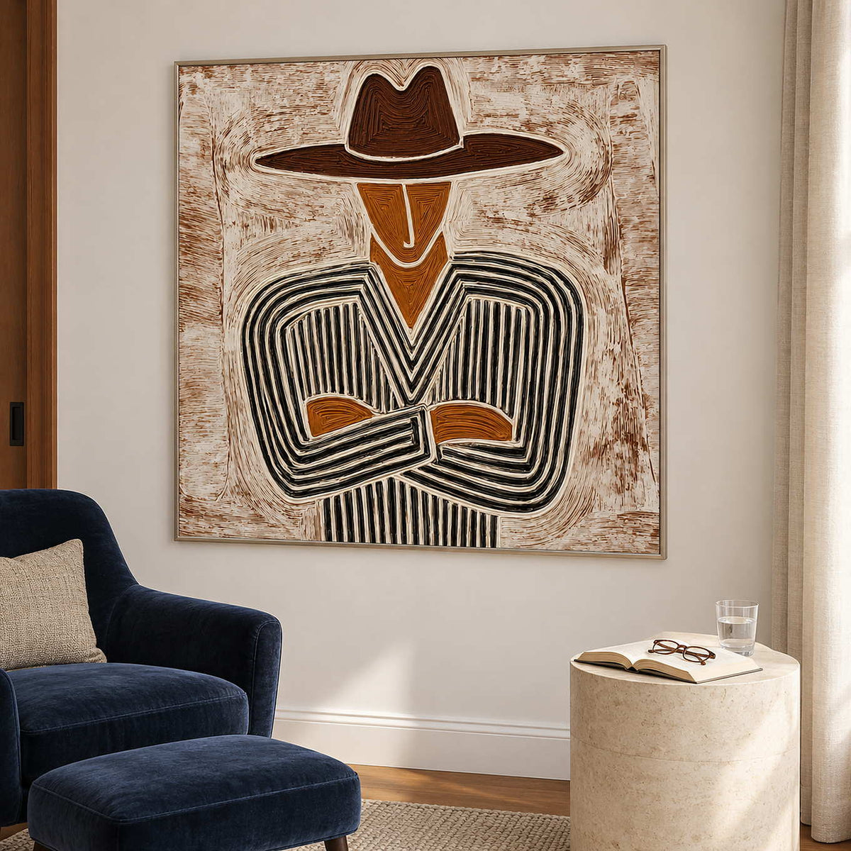 Neutral portrait beside a navy reading chair and ottoman with a pale cylindrical table.