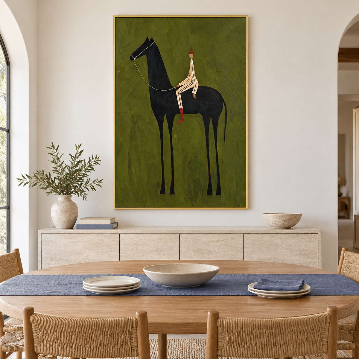 Tall horse-and-rider painting behind an oval dining table with woven chairs.
