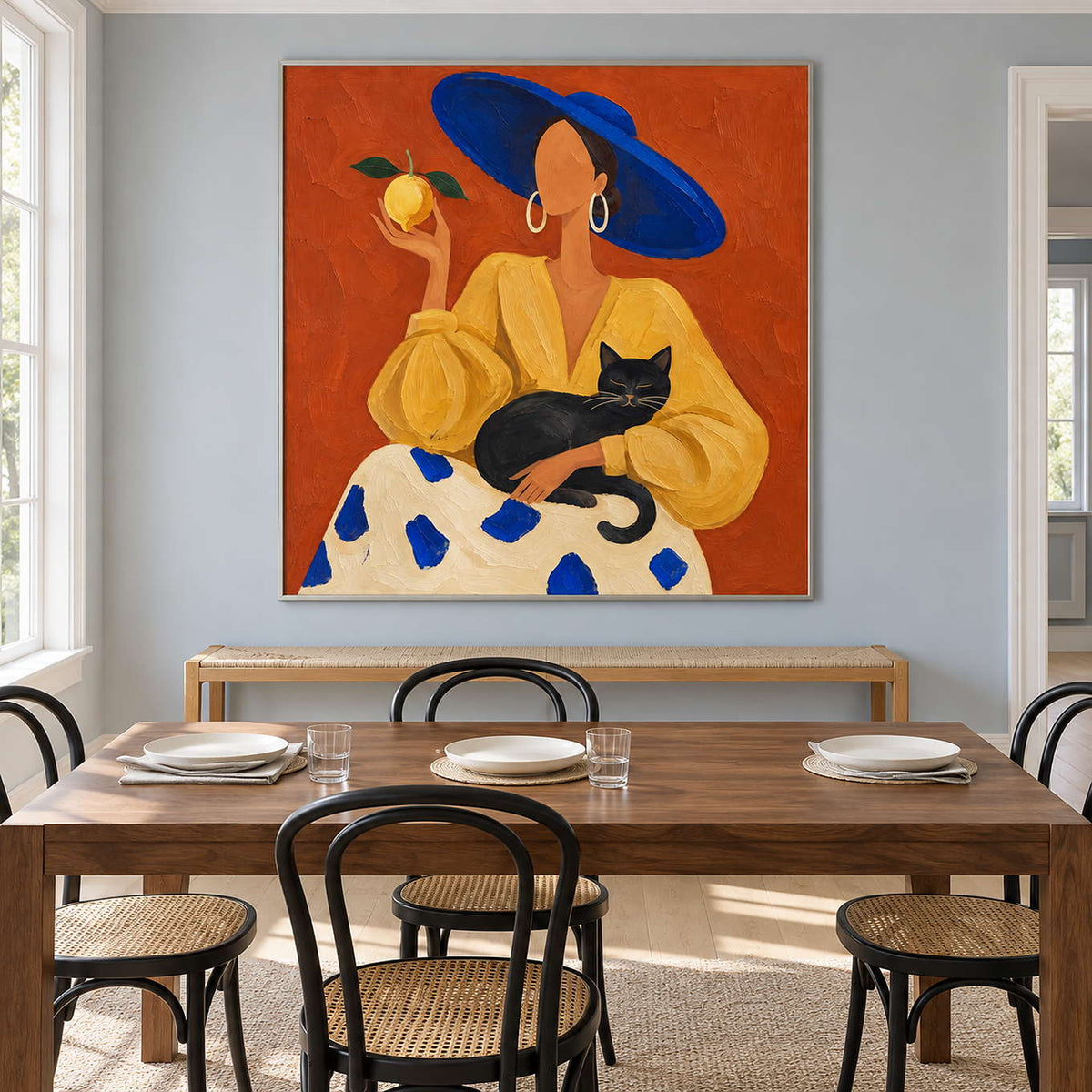 Colorful cat portrait behind a wooden table and black dining chairs.