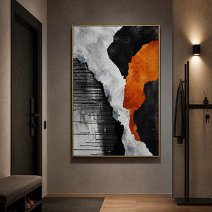 Gold framed orange and monochrome abstract artwork beside a dark entry door and coat hooks.