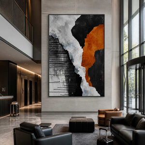 Black framed bold abstract artwork near hotel elevators, reception, and tall glass entrance doors.
