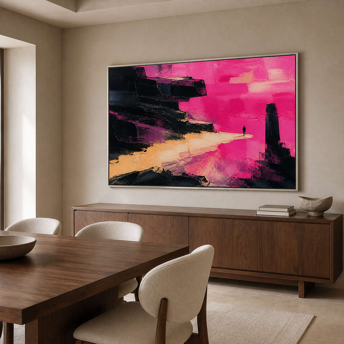 Pink textured wall art in a silver frame beside a dining table.