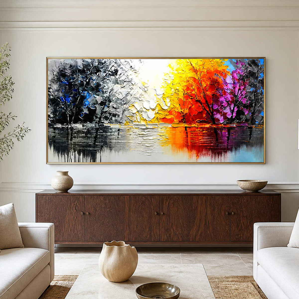 Gold-framed autumn lake painting above a dark cabinet between pale living room sofas.