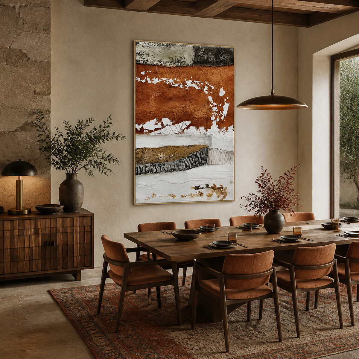 Gold framed rust and white abstract artwork overlooking a wooden dining table and upholstered chairs.