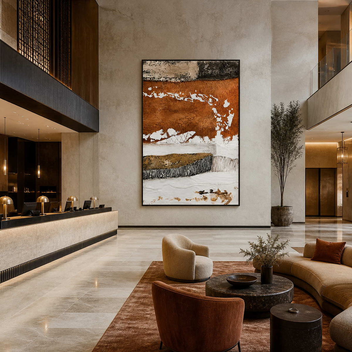 Black framed rust and white artwork beside a hotel reception desk in a tall lobby.