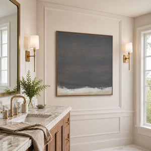 Wood framed tonal abstract artwork beside a marble vanity in a bathroom dry area.