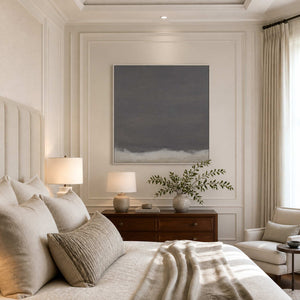 White framed gray abstract artwork with a pale lower edge above a bedroom dresser.