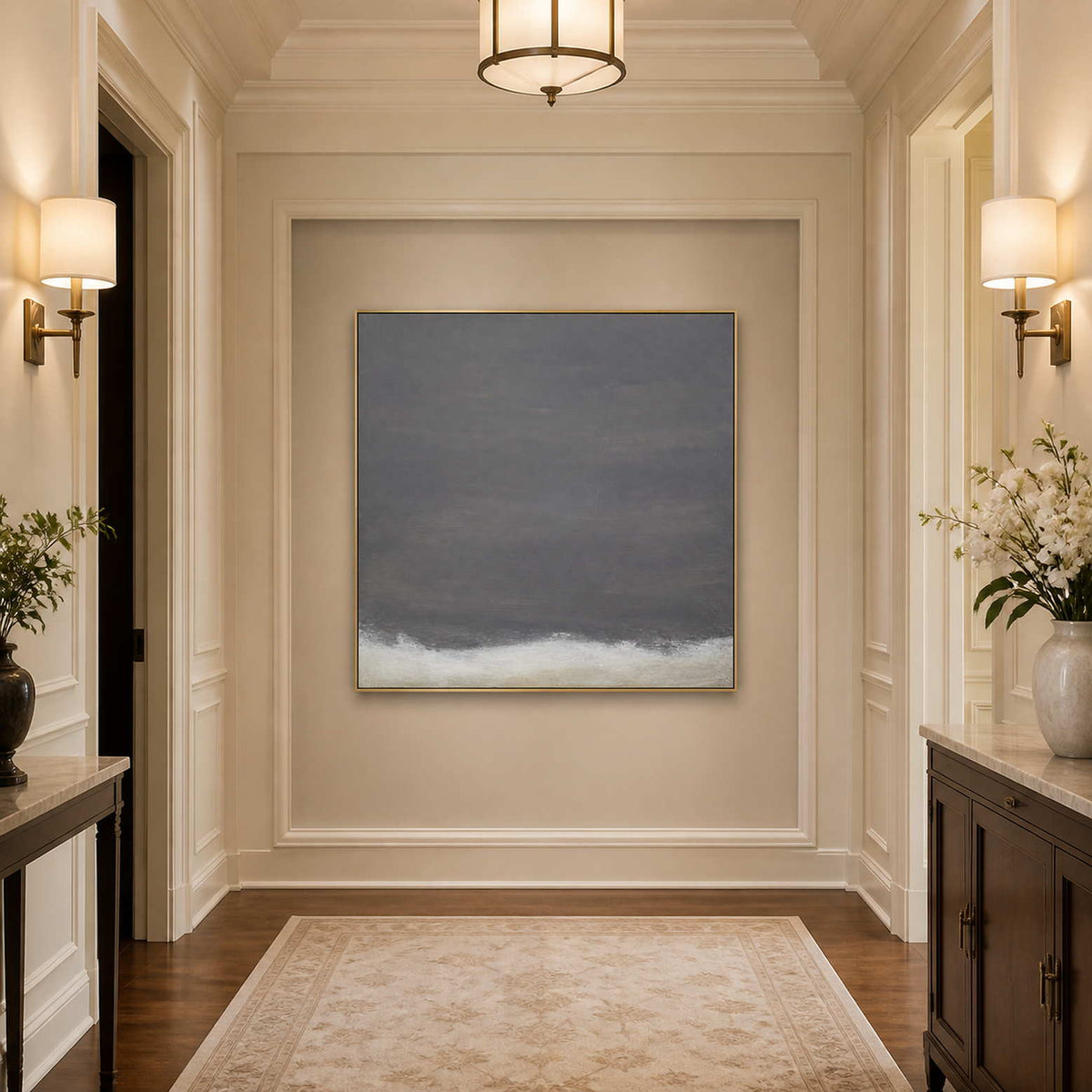 Gold framed charcoal gray abstract painting at the end of a softly lit hallway.