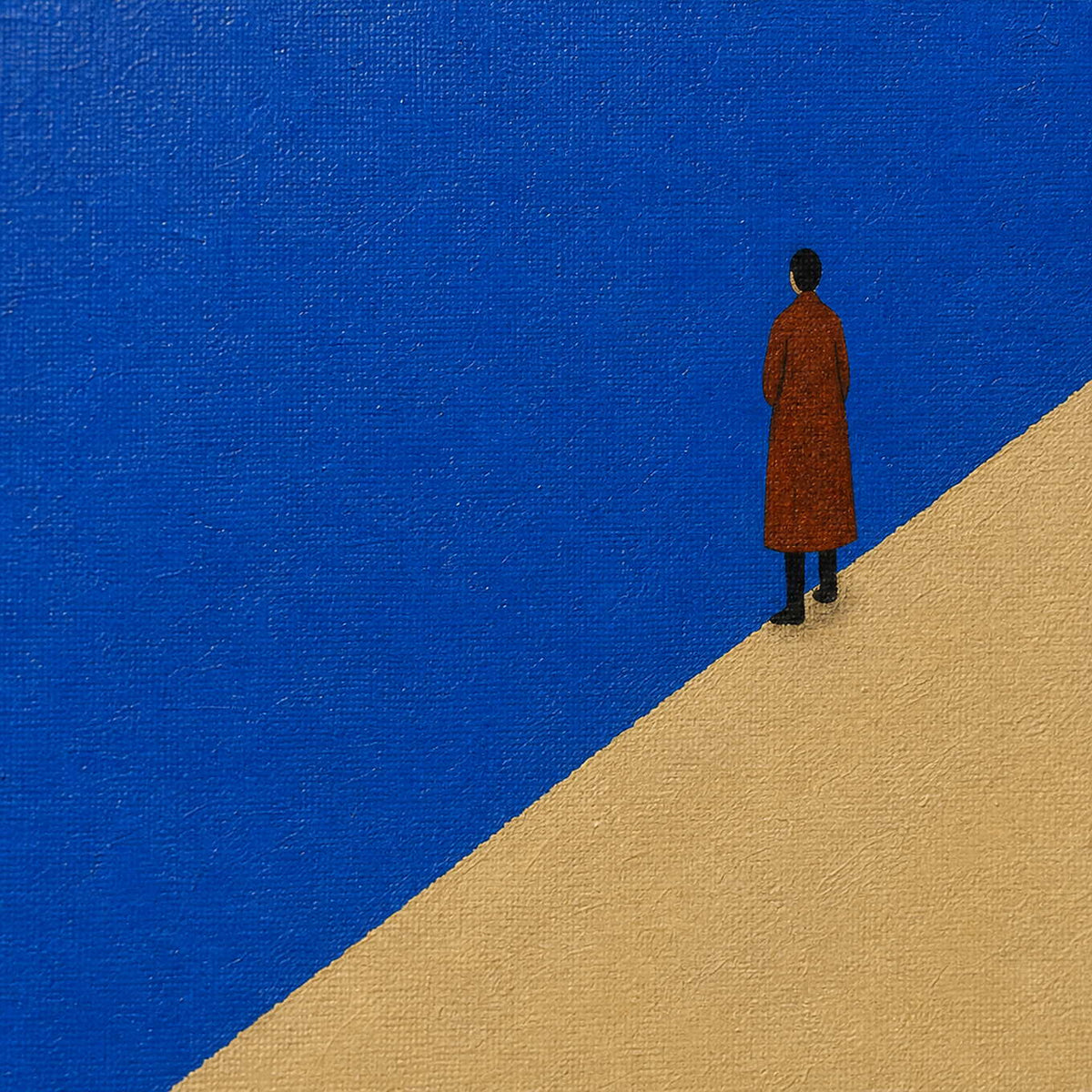 Close-up of the rust-red figure against cobalt blue and warm sand.