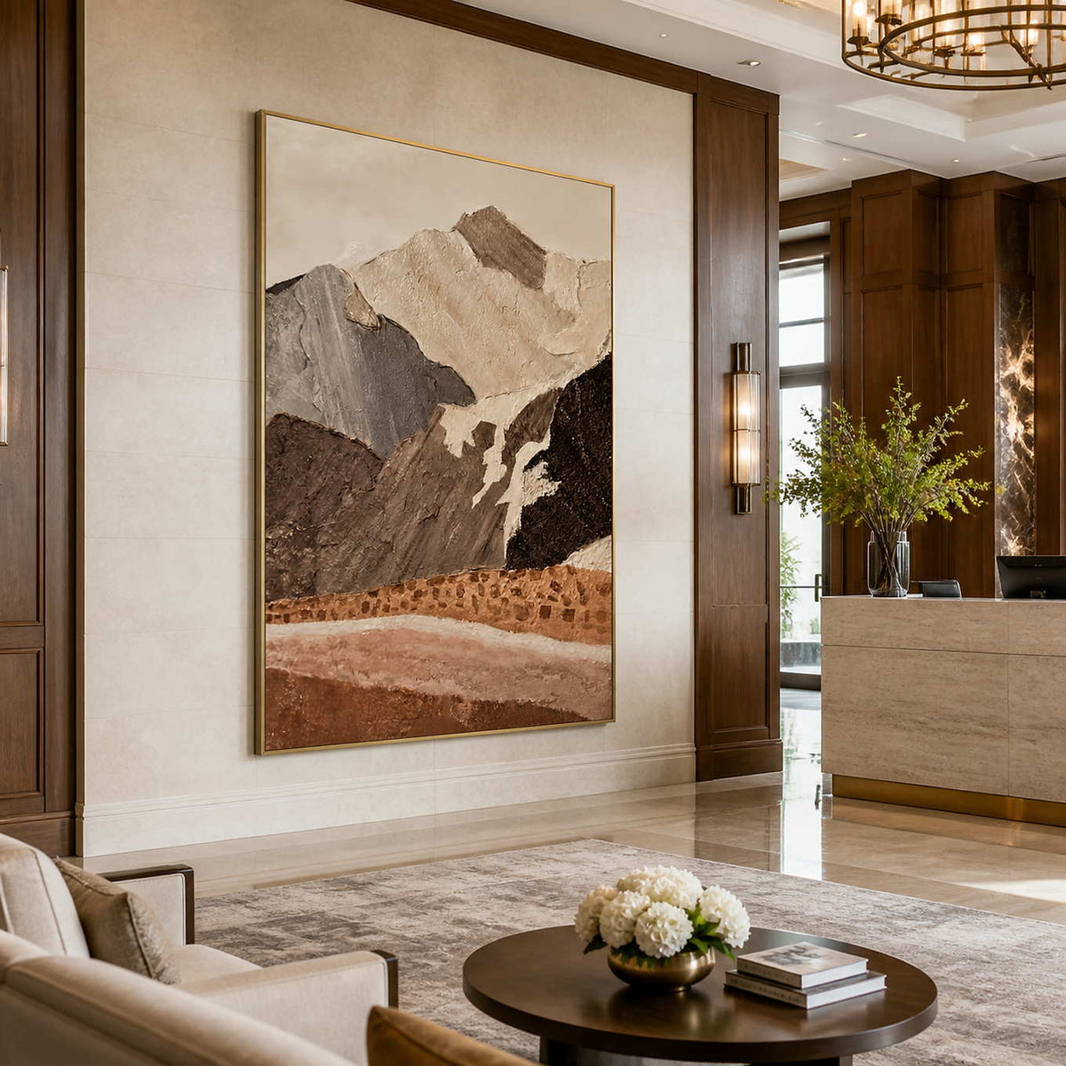Gold framed mountain artwork beside a stone reception counter in a wood paneled hotel lobby.