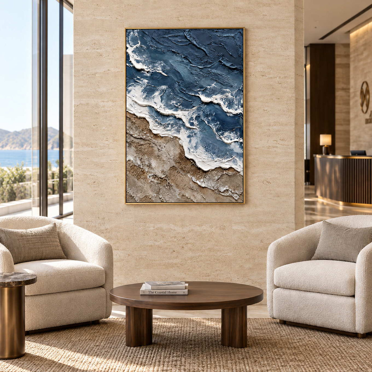 Beyond the Shore in a gold frame above two cream armchairs and a round wood table in a commercial lobby.