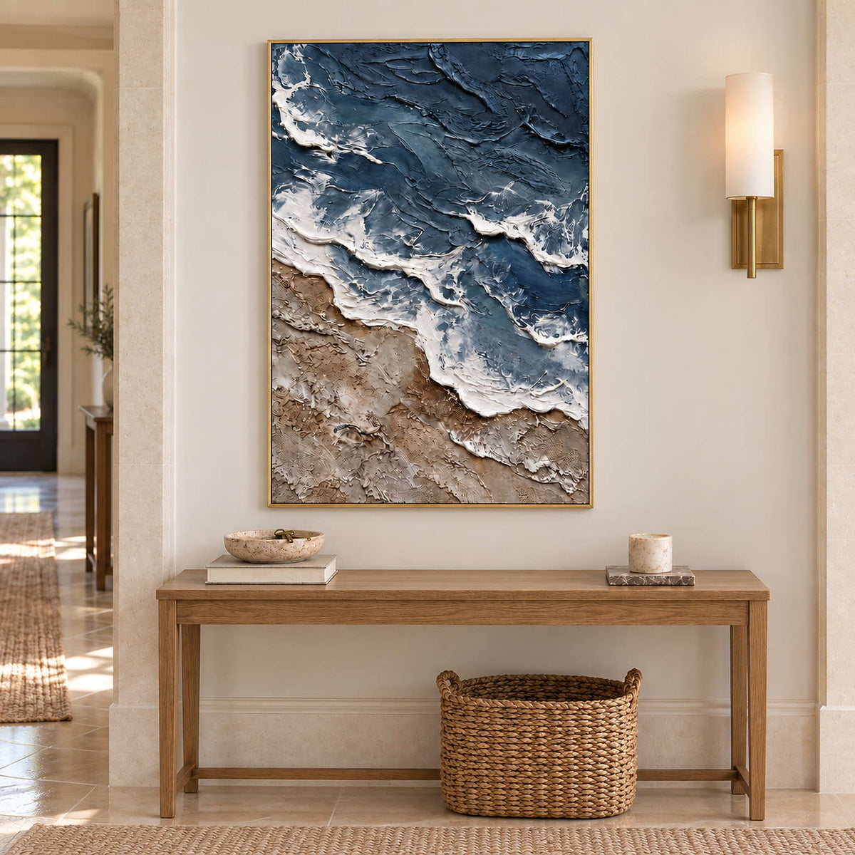 Beyond the Shore in a gold frame above a wood hallway console and large woven basket.