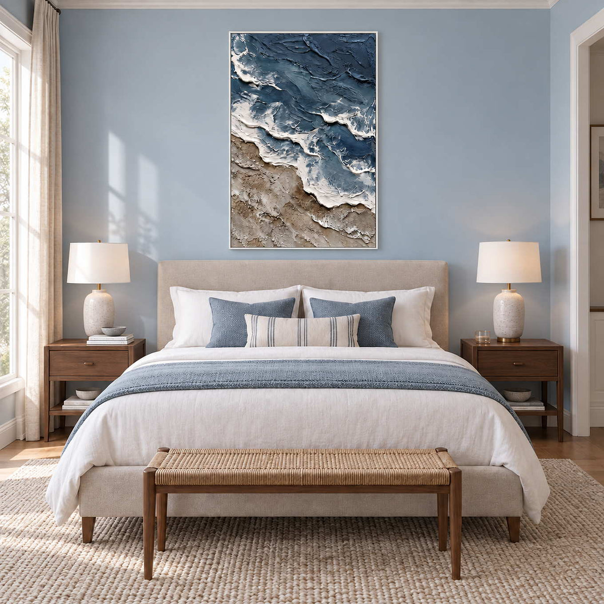 Beyond the Shore in a white frame above a cream bed with blue-gray linens and a woven bench.