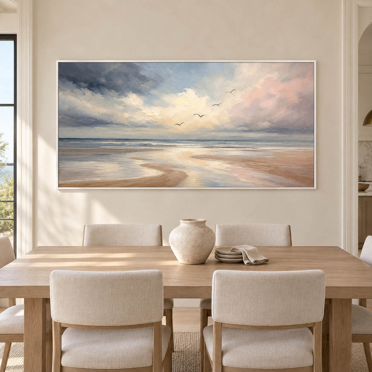 Hand-painted coastal wall art with pale blue, blush, and ivory shoreline, displayed in a dining room in a white frame.