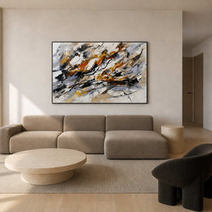 Black, rust, and ochre abstract wall art displayed in a warm white modern living room.