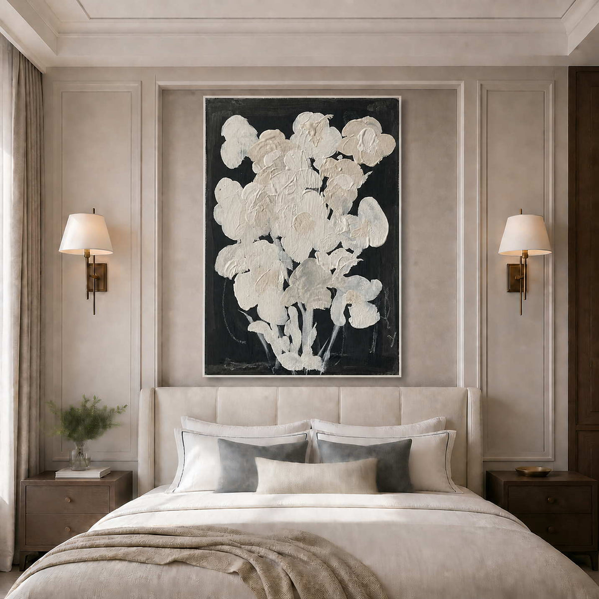 White framed floral artwork above a neutral bed with layered pillows and wall lamps.