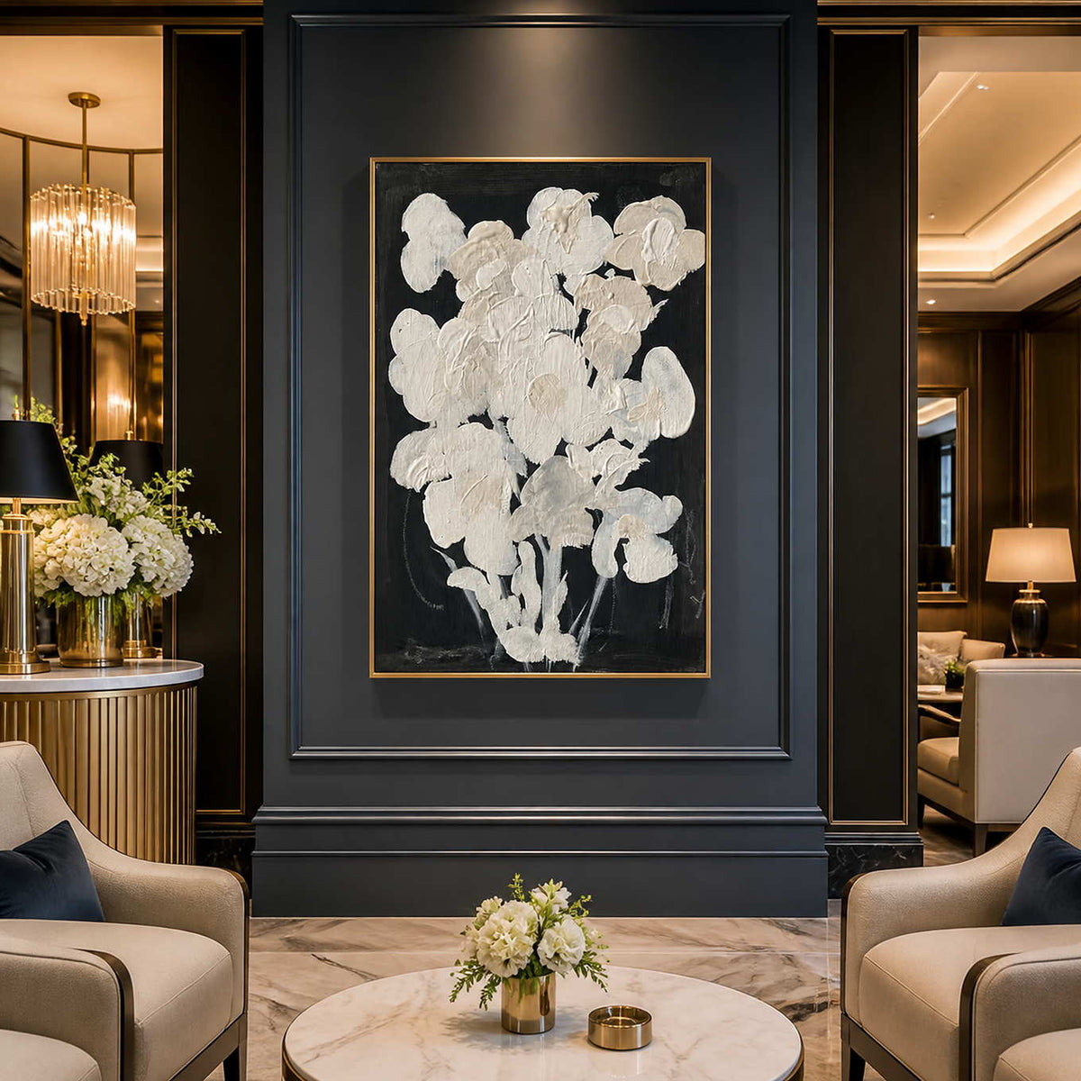 Gold framed cream floral artwork on a dark hotel lobby wall between lounge chairs.