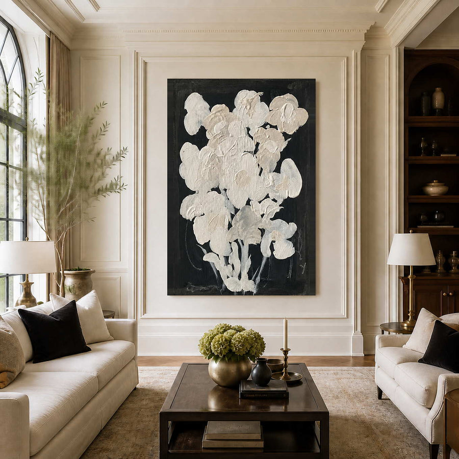 Frameless cream floral artwork between sofas in a bright living room with tall windows.