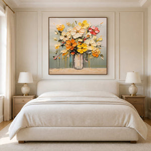 Wood framed warm floral painting above a cream bed between matching bedside lamps.