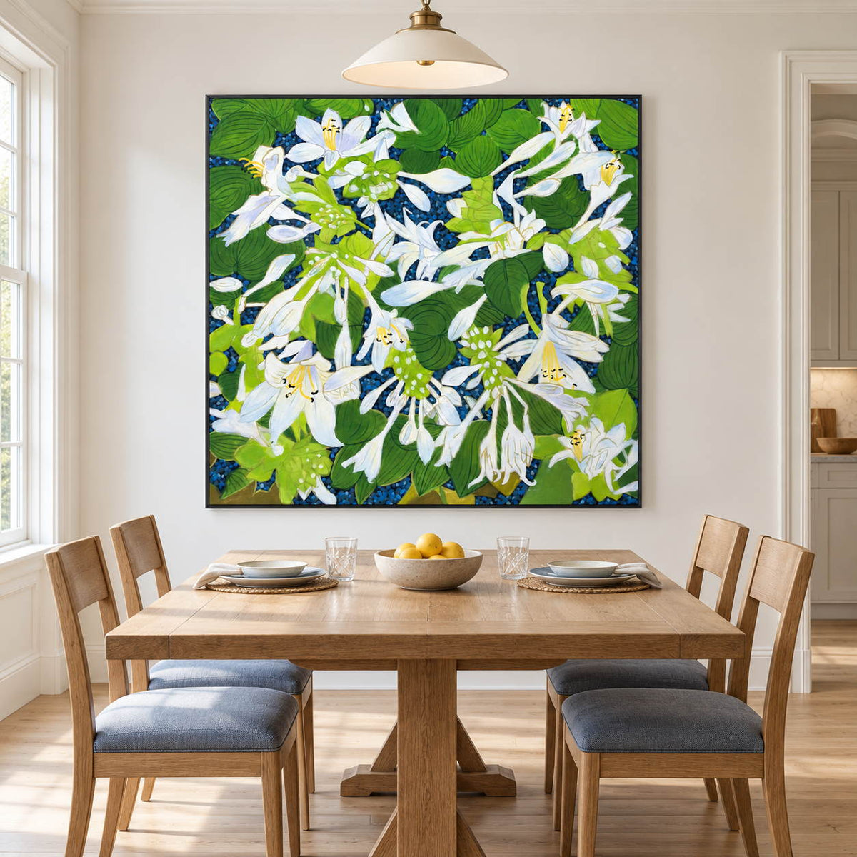 Artwork showing white flowers and broad green leaves over a deep blue ground in a dining area beside the table, with a black frame.