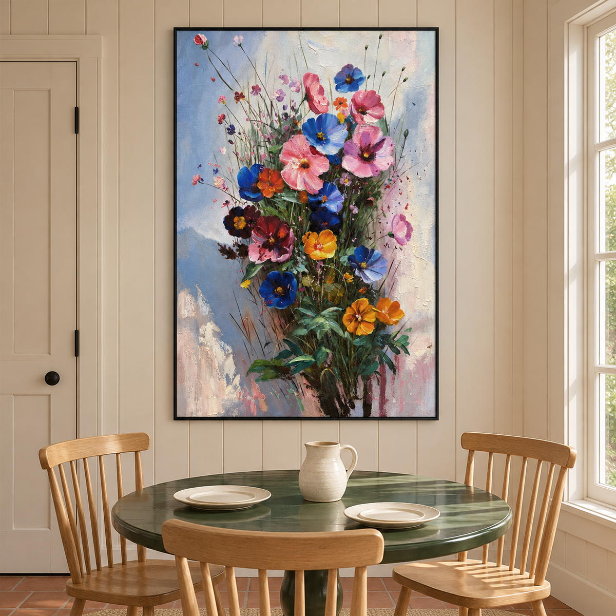 Pink, blue and orange flowers on fine stems with dark green leaves against pale blue in an artwork with a black frame, displayed in a dining area beside the table.