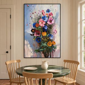 Pink, blue and orange flowers on fine stems with dark green leaves against pale blue in an artwork with a black frame, displayed in a dining area beside the table.