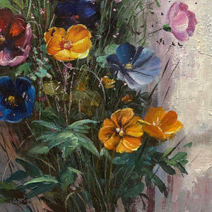 Close-up of orange flowers, blue petals and overlapping dark green leaves.