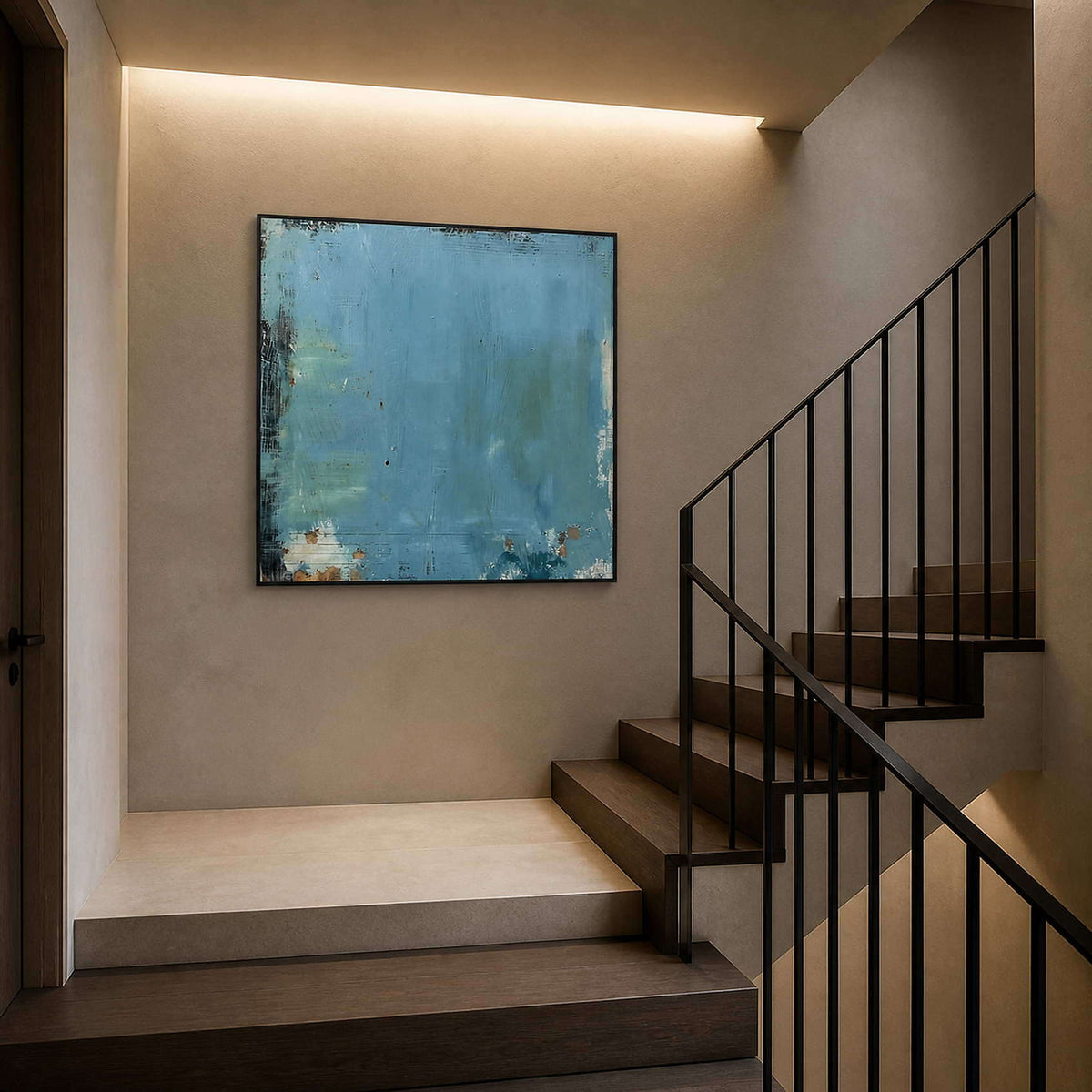 Square blue abstract artwork displayed at a dark wood stair landing.