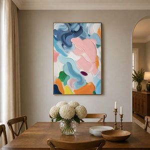 Blush and blue abstract wall art adds fresh color above a wood dining table.