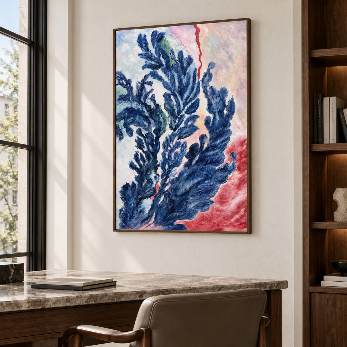 Artwork showing branching deep blue forms curling upward over pale pink, cream and red in a study with a desk, with a brown wood-look frame.