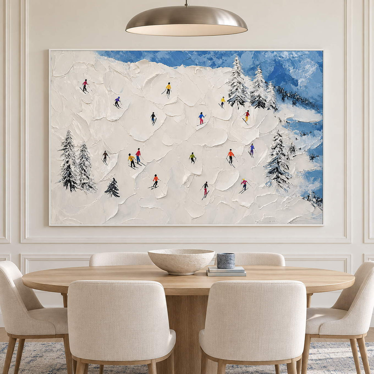 Hand-painted snowy mountain canvas with colorful skiers and pine trees, displayed in a dining room in a white frame.
