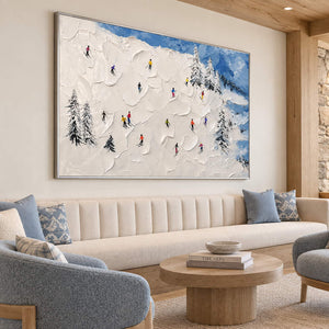 Hand-painted snowy mountain canvas with colorful skiers and pine trees, displayed in a lounge in a silver frame.