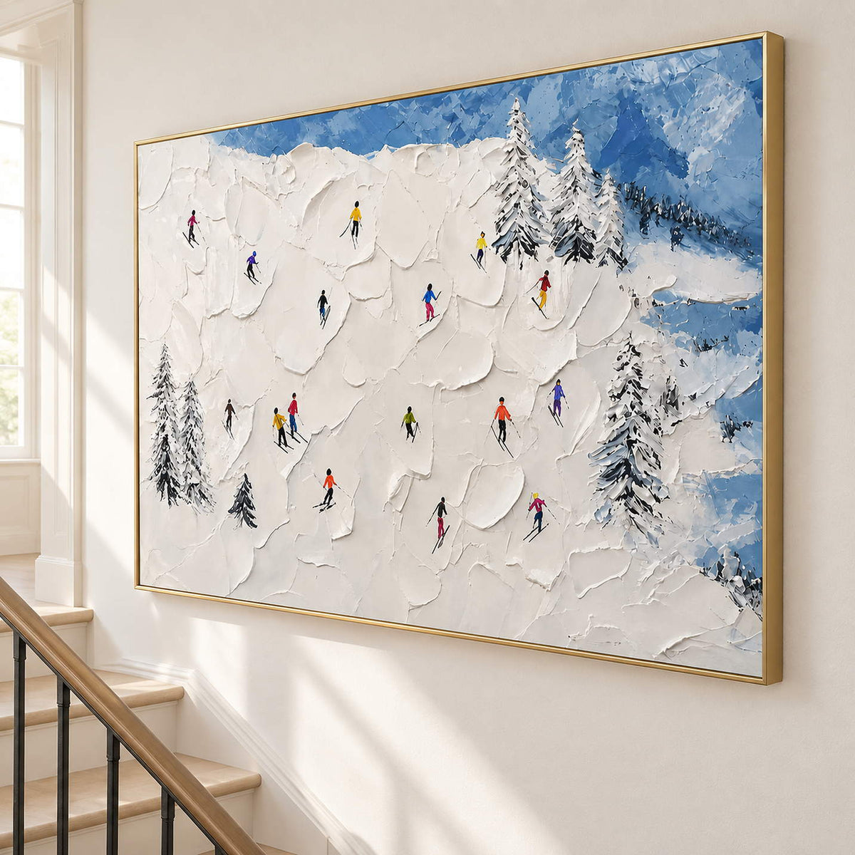 Hand-painted snowy mountain canvas with colorful skiers and pine trees, displayed beside a staircase in a gold frame.