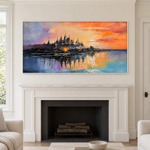 A distant castle reflected in water beneath an orange sunset in a white frame, displayed above a fireplace.