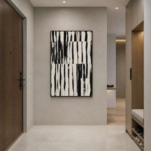 Black and white striped abstract artwork facing a minimalist entryway with wooden cabinetry.