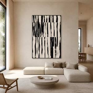 Black framed striped abstract artwork above a cream sectional in a bright living room.