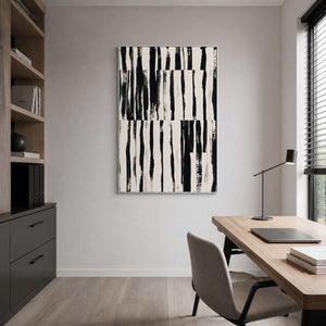 Silver framed black brushstroke artwork beside a home office desk and bookshelves.