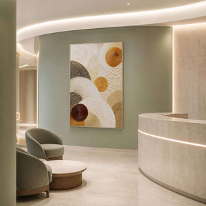 Layered circles in gold, brown, and ivory wall art in a contemporary commercial lobby.