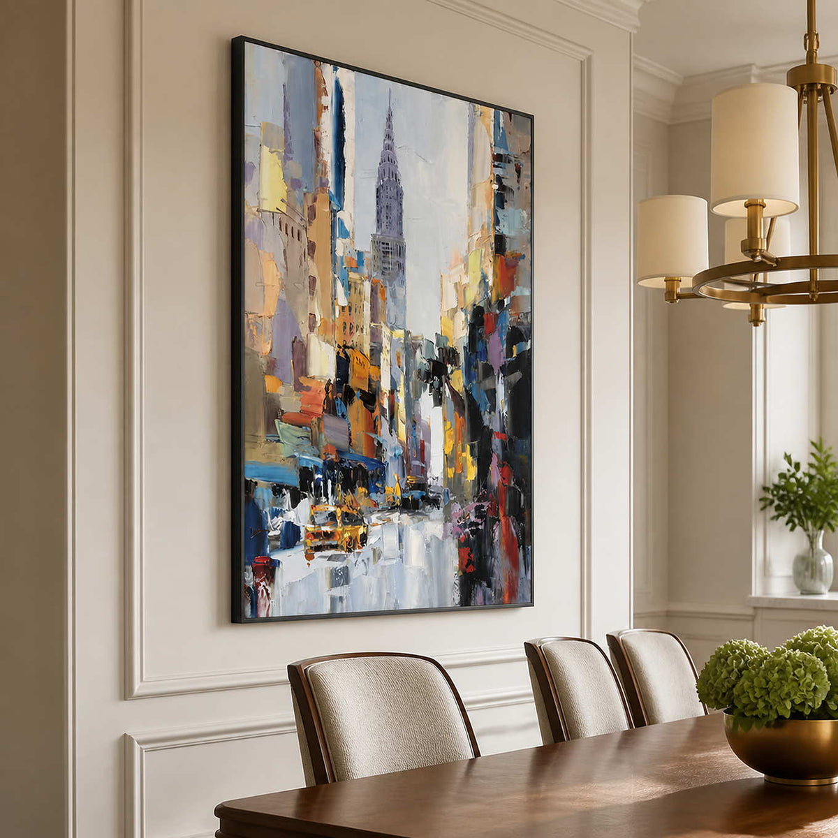 Black framed colorful cityscape beside a wooden dining table under a brass chandelier.