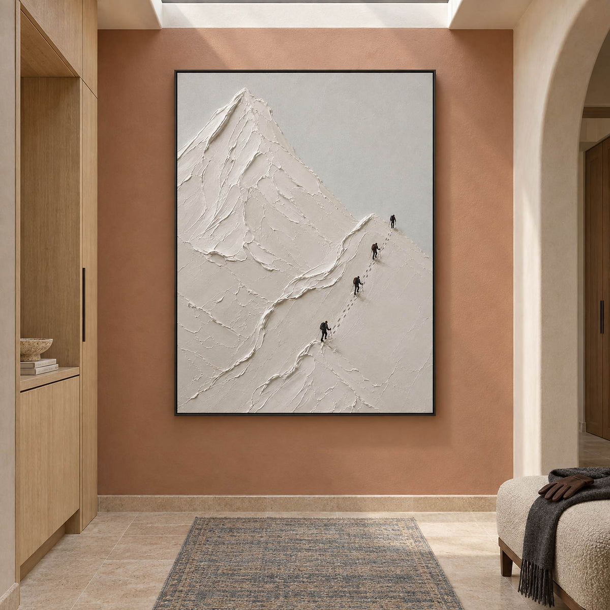 Four climbers ascending sculpted white mountain ridges in a vertical composition, displayed in a hallway in a black frame.