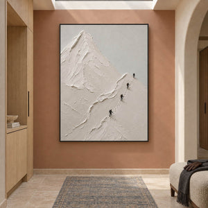 Four climbers ascending sculpted white mountain ridges in a vertical composition, displayed in a hallway in a black frame.